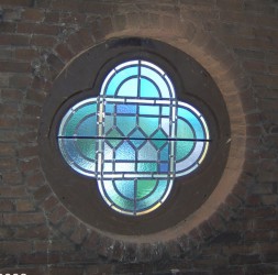 Single stained glass window frame, set into brick.